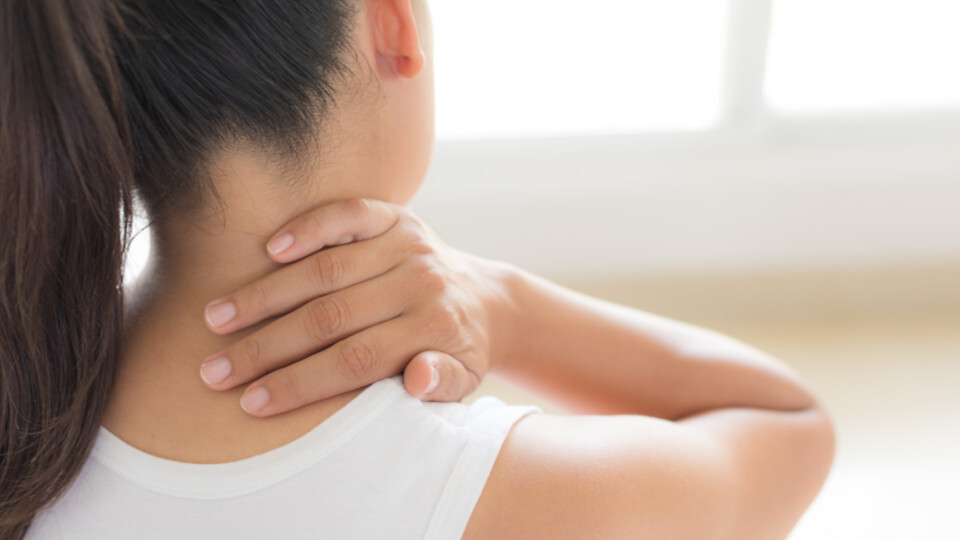 Eine Frau mit  Nackenschmerzen aufgrund von Craniomandibulärer Dysfunktion