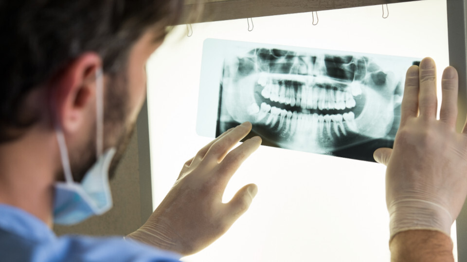 Ein Zahnarzt sieht sich eine Röntgenaufnahme an